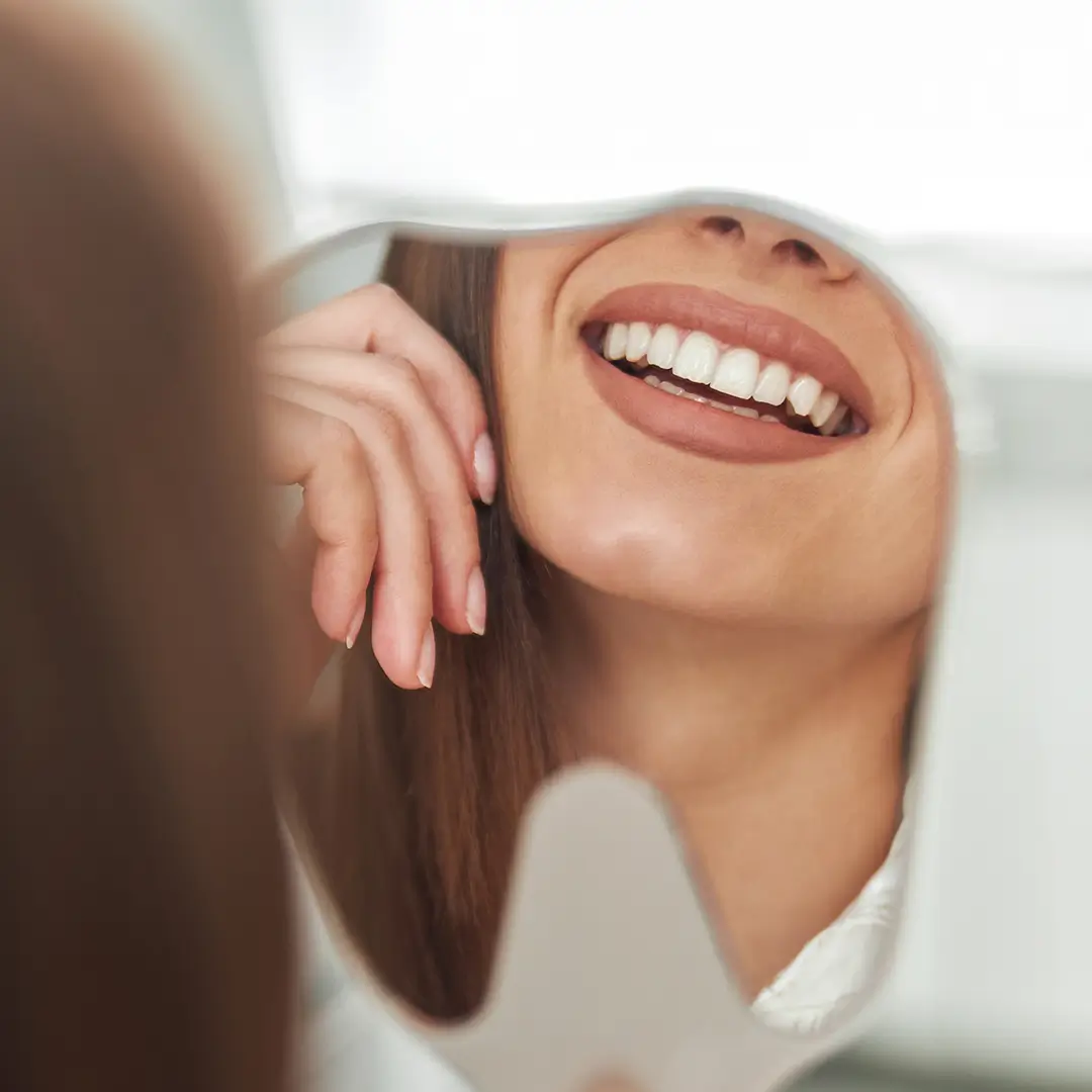 An Image Of A Face Of A Woman Looking At The Mirror, Where Only  Her Teeth Are Showcased